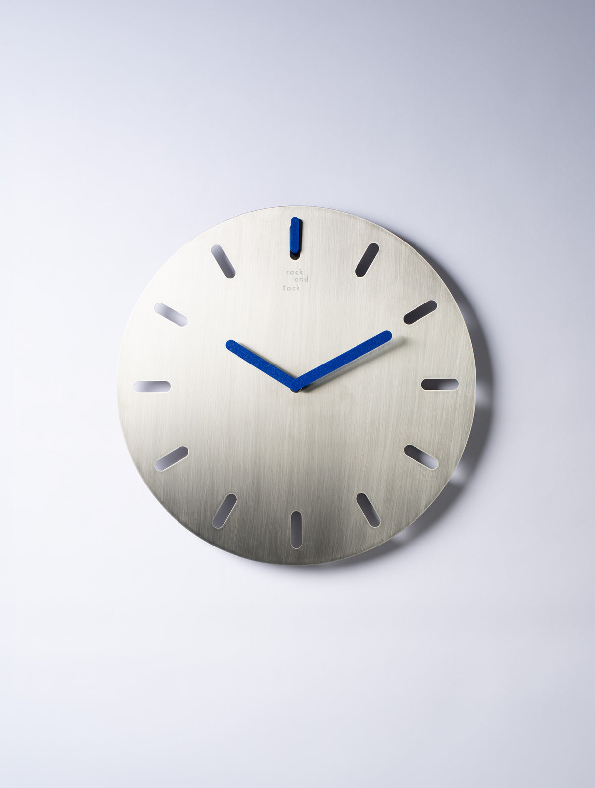 שעון קיר Time Frame של Rack and Tack עם לוח מתכת מחורץ בגימור מוברש, מחוגים ומתלה בצבע כחול